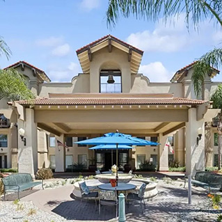 A building with a patio and a blue umbrella.